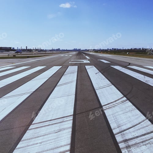 Preview: Airport Runway Leading to City Skyline