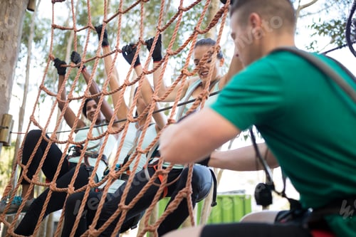 Preview: Coach assisting trainee in net climbing