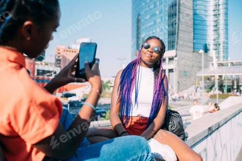 Preview: two women sisters outdoor using smart phone taking each others photos
