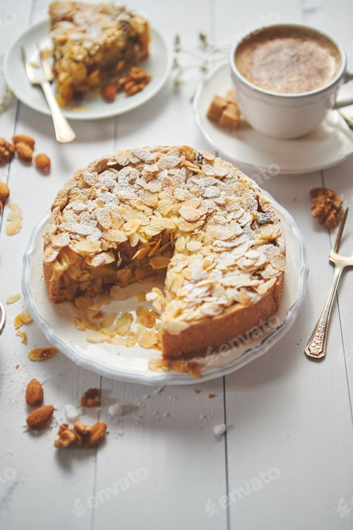 Preview: Whole delicious apple cake with almonds served on wooden table