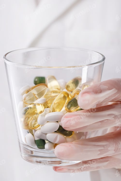 Preview: Doctor holding glass of pills