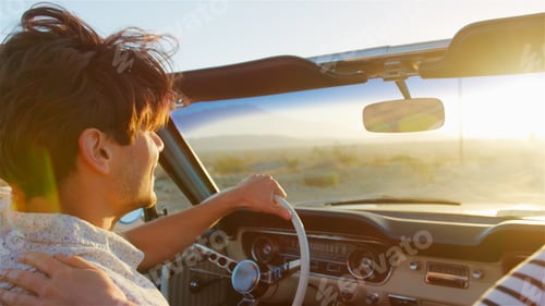 Preview: Close Up Of Couple Driving Classic Open Top Car On Road Trip Through Countryside At Sunset