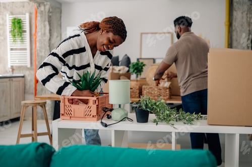 Preview: Happy couple unpacking boxes and furnishing new home together