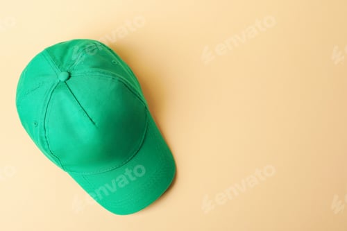 Preview: Green baseball hat on beige background, top view. Space for text