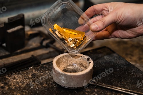Preview: Jeweler placing gold into a crucible prior to melting.