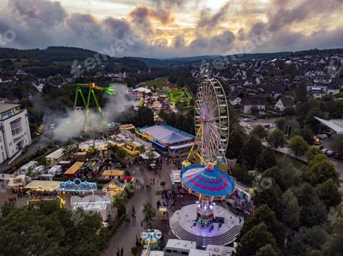 Preview: Overhead shot of the countryside attraction park with a Ferris wheel under a cloudy sky