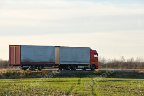 Preview: Semi-truck with cargo trailer driving on highway hauling goods in evening. Delivery transportation