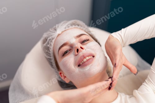 Preview: close-up of a girl's face with a cream or mask during a cosmetic procedure in a beauty salon