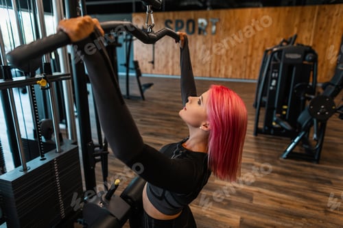 Preview: Beautiful sporty woman in black fashionable sportswear working out in the gym