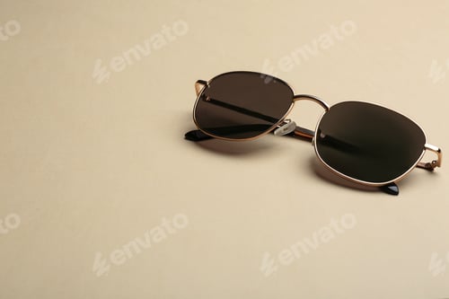 Preview: Stylish sunglasses on beige background, space for text. Fashionable accessory