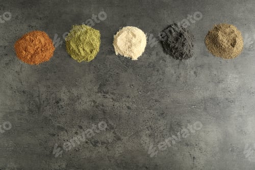 Preview: Different superfood powders on grey table, flat lay. Space for text