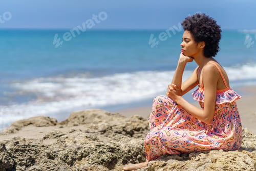 Preview: Thoughtful black woman admiring sea