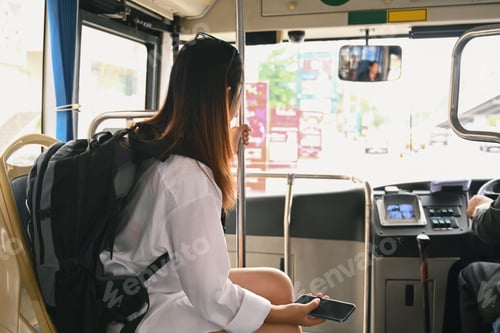 Preview: Female traveler with backpack sitting in public transportation.