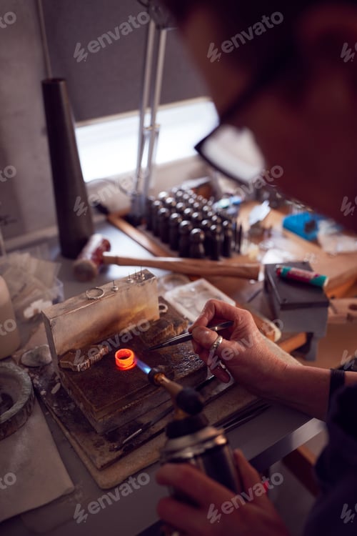 Preview: Close Up Of Male Jeweller Working On Ring With Blowtorch In Studio
