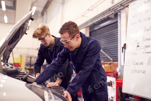 Preview: Two Male Students Studying For Auto Mechanic Apprenticeship At College Working On Car Engine