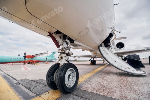 Preview: View from below. Turboprop aircraft parked on the runway at daytime