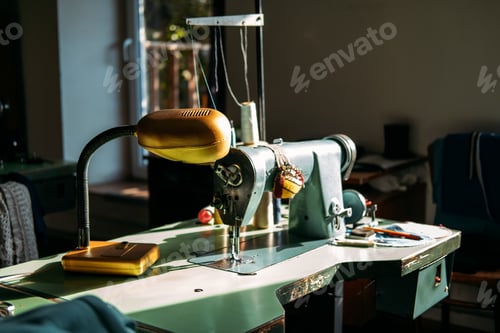 Preview: Sewing machine on table in factory in sun light. Small business, fashion designe, Tailor working