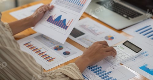 Preview: Close up of businessman or accountant hand holding pen working on calculator to calculate business