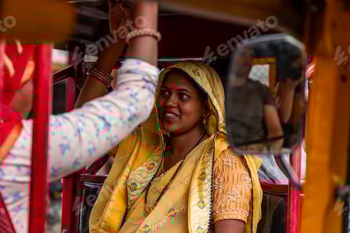 Preview: Indian woman wearing yellow sari riding auto rickshaw in Jaipur