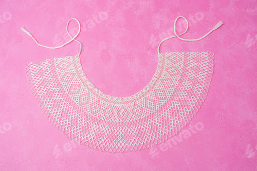 Preview: White beaded necklace with intricate design on vibrant pink background