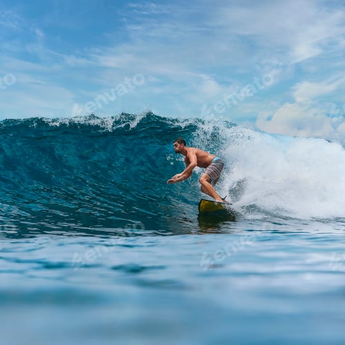 Preview: Shirtless male surfer on a wave at sunny day