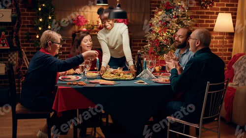 Preview: Beautiful woman bringing main course to Christmas dinner table