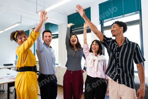 Preview: Happy business team celebrating success raising hands in office