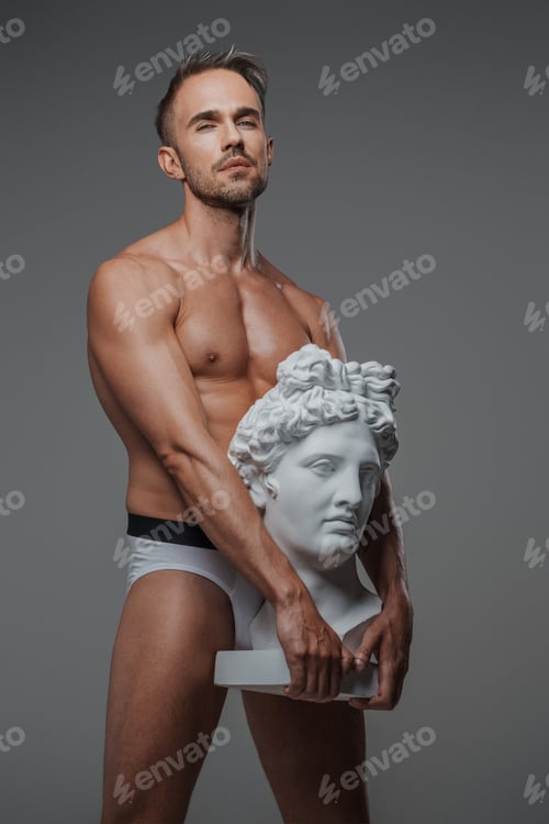 Preview: An attractive male model, dressed only in underwear on a gray backdrop