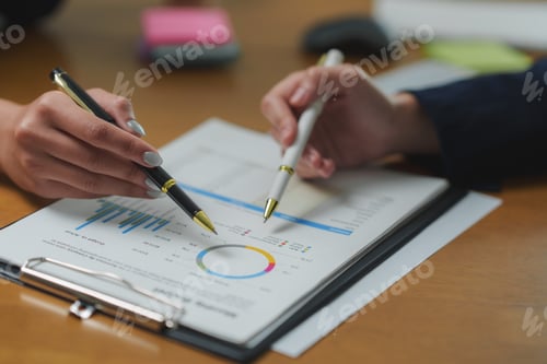 Preview: Businesswomen analyzing financial charts and statistics using pens