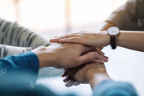 Preview: Closeup image of people putting their hands in stack together