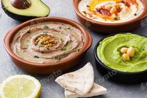 Preview: Muhammara, hummus and guacamole dips with pita bread, avocado and lemon