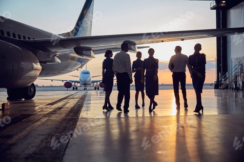 Preview: Unrecognizable people standing near the aircraft in the aviation hangar