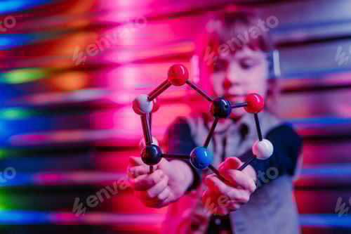 Preview: Little girl holding molecular model on the colorful neon background
