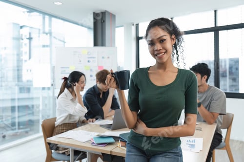 Preview: Portrait of a happy woman standing in a corporate office during a team analysis meeting. Young