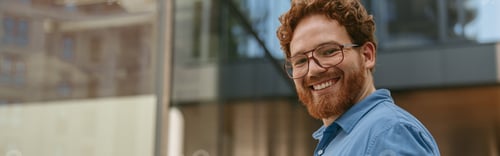 Preview: Smiling male manager with digital tablet is drinking coffee during break outside of office