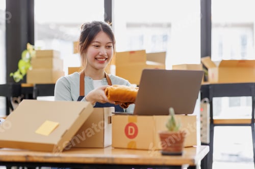 Preview: Startup small business SME. young Asian entrepreneurs using laptop computer check online orders and