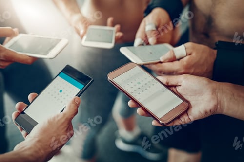 Preview: Closeup shot of a group of people using their cellphones together at the gym