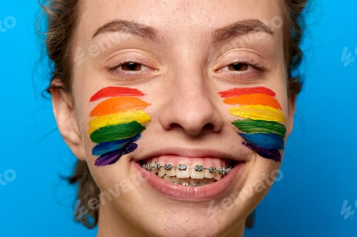 Preview: Girl with pride flag painted on her cheeks smiling