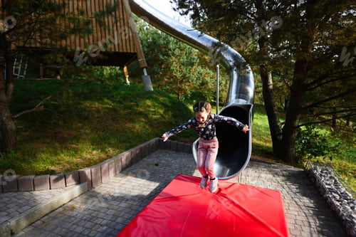 Preview: Little girl having fun on the playground in the park. Healthy lifestyle.