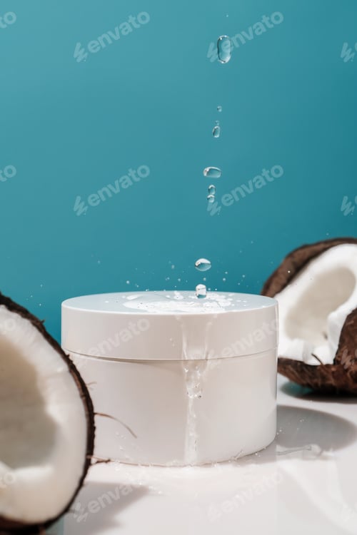 Preview: Two halves of coconut and a jar of cosmetics on a blue background with water drops