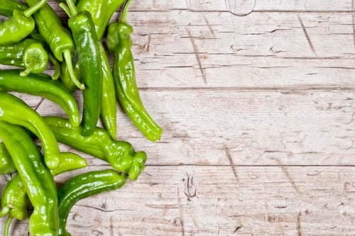 Preview: Fresh green raw peppers on rustic wooden table background.