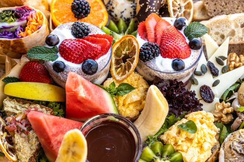 Preview: Closeup of assorted fruits, cheese, bread, and dessert on a platter