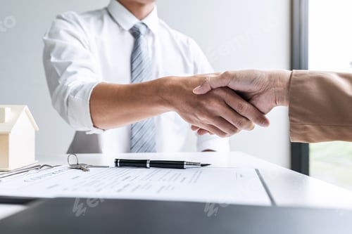 Preview: Real estate agent and customers shaking hands together celebrating finished contract after signing
