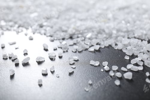 Preview: Scattered white natural salt on black table, closeup