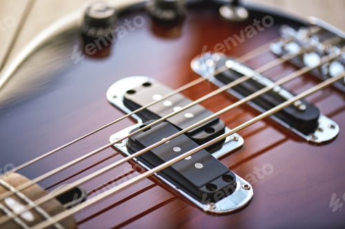 Preview: Guitar Lessons. Close-up view of electric guitar body with metal strings, volume and tone controls
