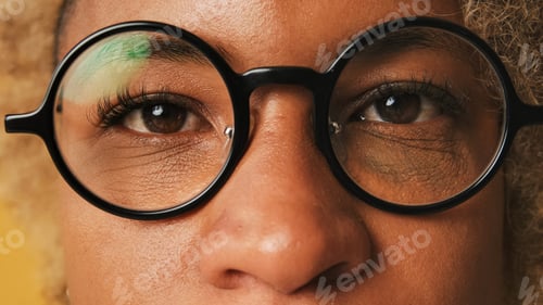 Preview: Close-up of girl's eyes, eyes and looks into the camera isolated on orange background