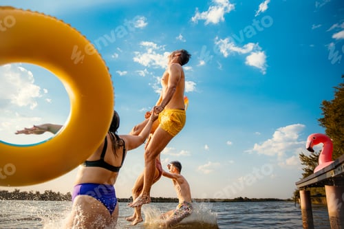 Preview: Group of friends having fun enjoying a summer day jumping and swimming at the lake.