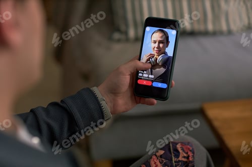 Preview: Young Caucasian Man Using Dating App on Smartphone While Sitting Indoors