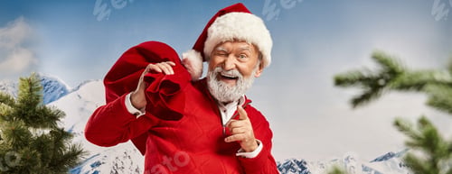 Preview: playful man in Santa costume winking and pointing finger at camera, Merry Christmas, banner