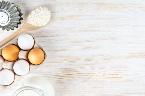Preview: Baking Ingredients Four, Eggs, Milk, Bakeware on White Wooden Background With Copy Space